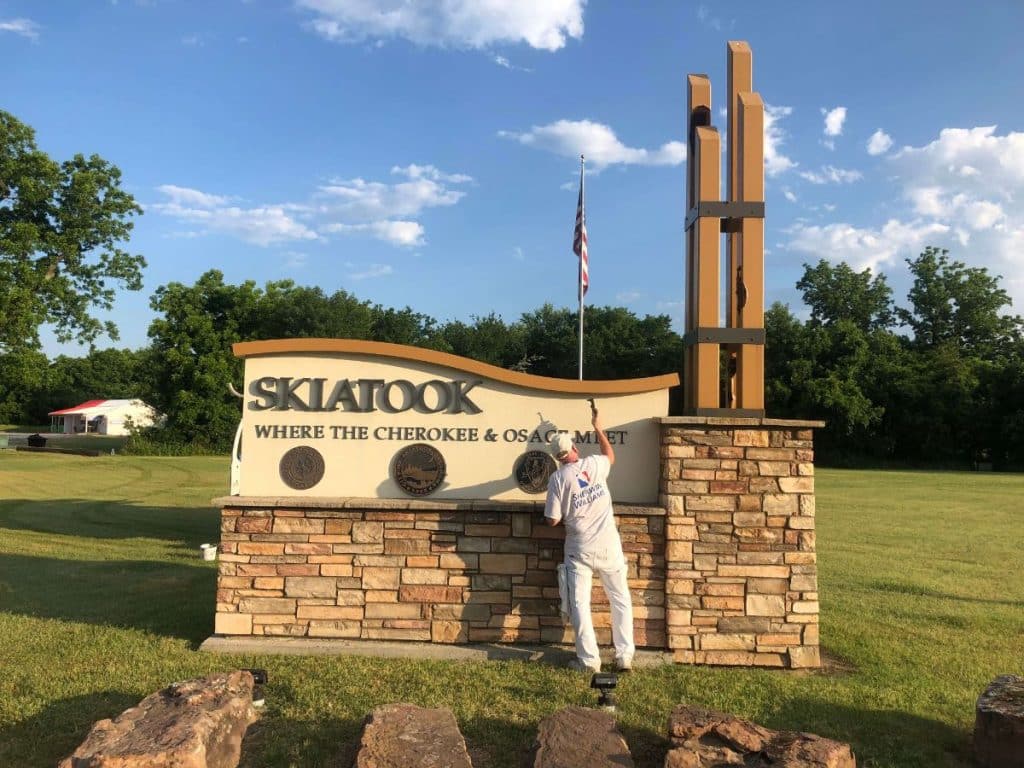Painter working on Skiatook welcome sign monument. Painter working on Skiatook welcome sign monument.