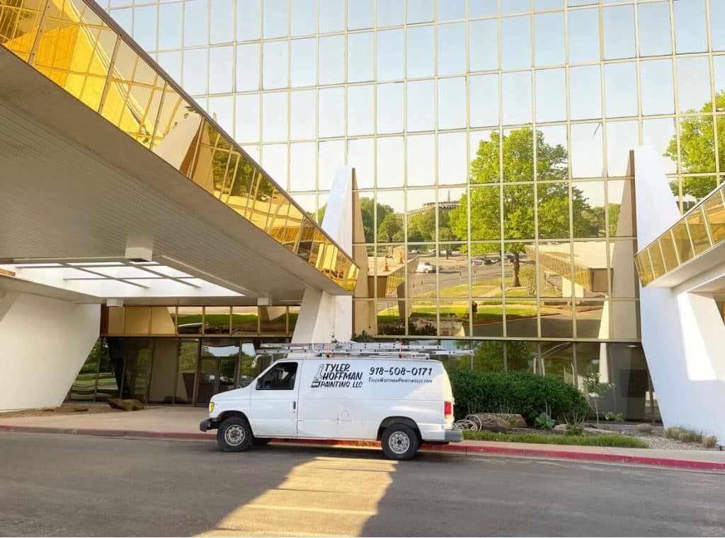 Tyler Hoffman Painting van parked outside modern glass office building. Tyler Hoffman Painting van parked outside modern glass office building.