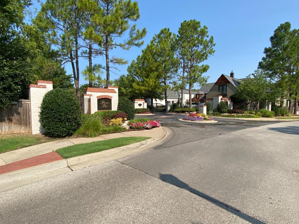 Residential neighborhood entrance with landscaped sign and gated drive. Residential neighborhood entrance with landscaped sign and gated drive.