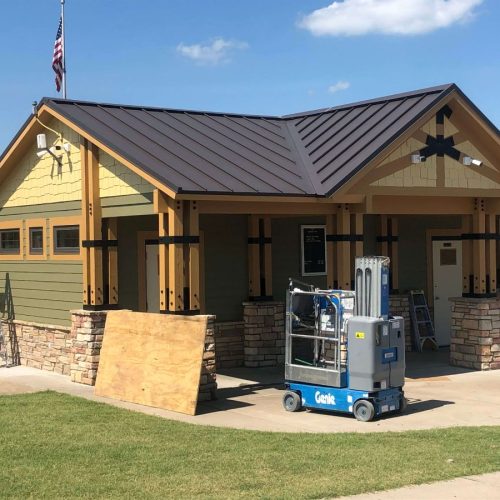 Freshly painted exterior building with construction equipment nearby